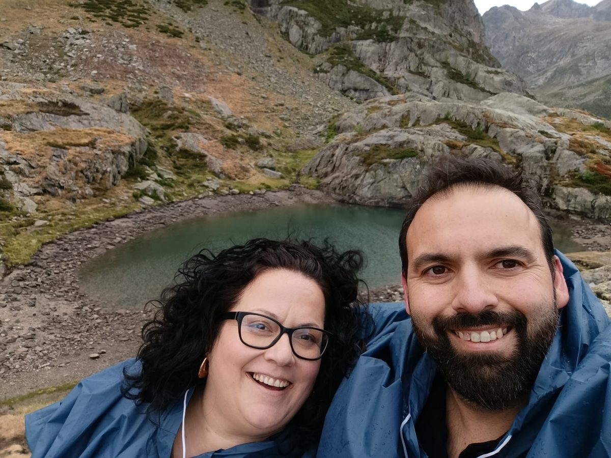 José Luis e Inma junto a un lago de montaña, con chubasqueros